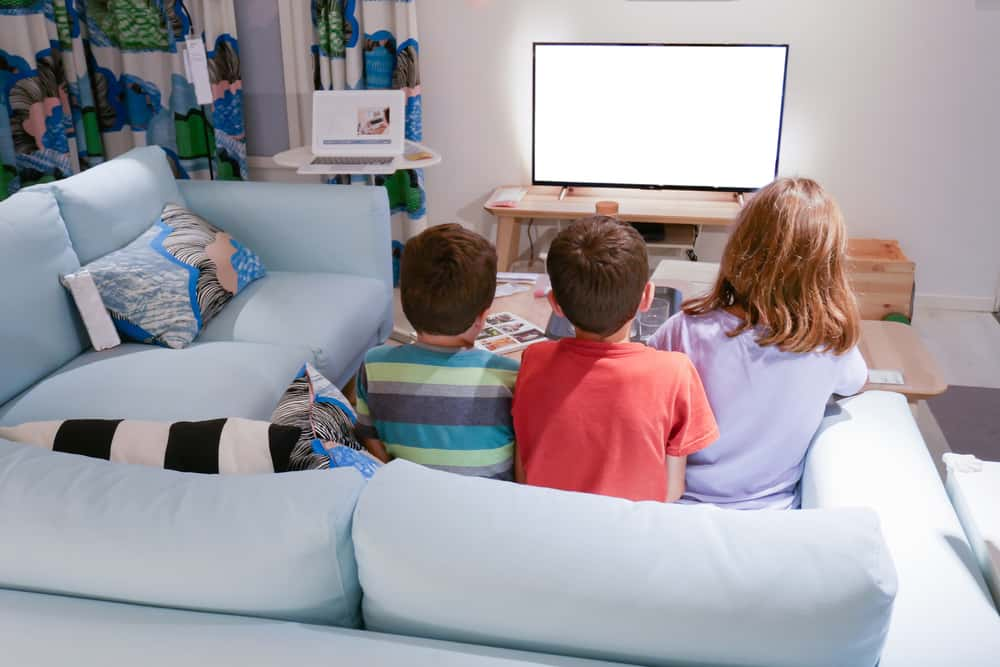 The children are watching tv now. A child watching TV back view.