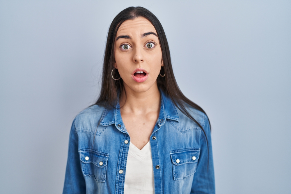 shocked woman standing over blue background