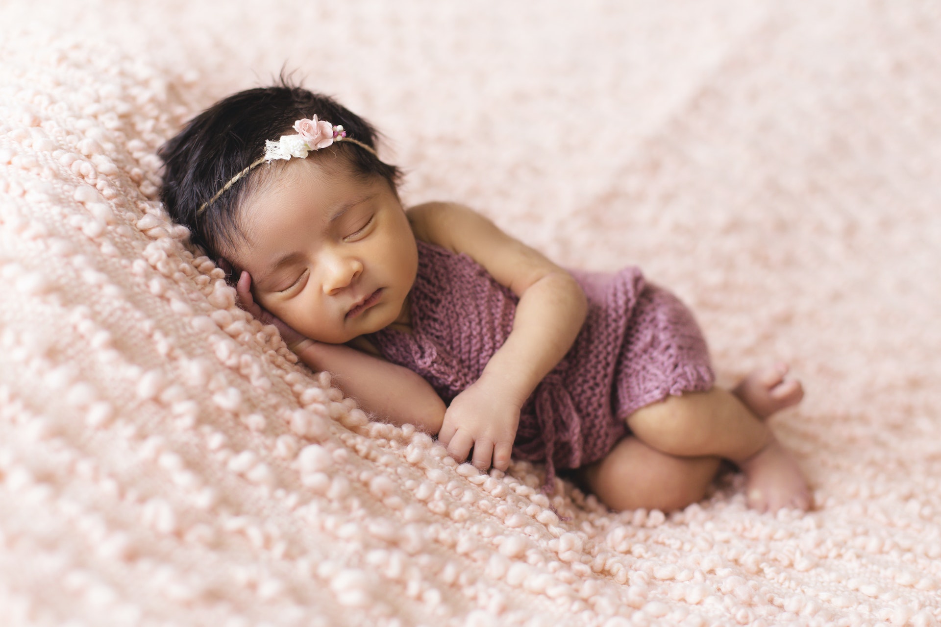 Newborn baby sleeping on pink blanket