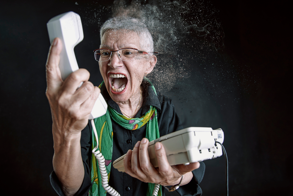 Angry older woman yelling  at the person on the phone