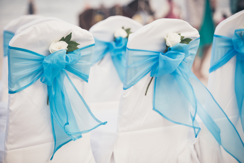 White Wedding chairs with  blue ribbons