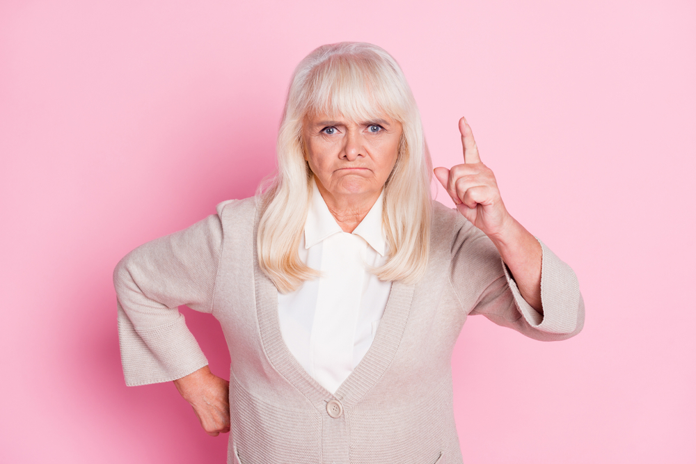 Photo of angry older  woman pointing finger   at someone