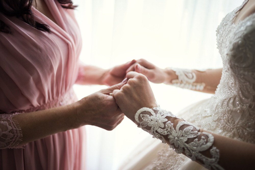 Bride on wedding day holding her grandmother's hands