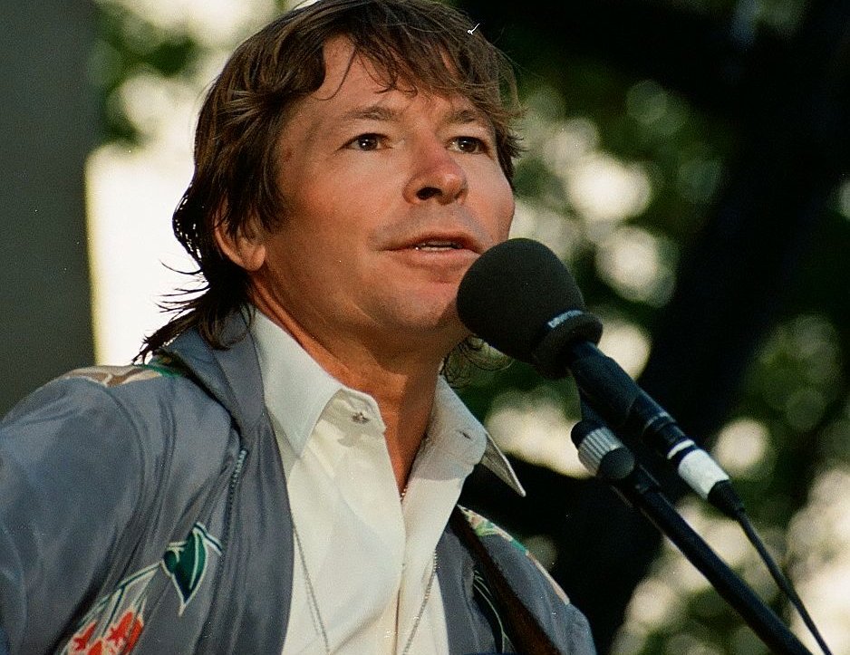 John Denver singing on a microphone